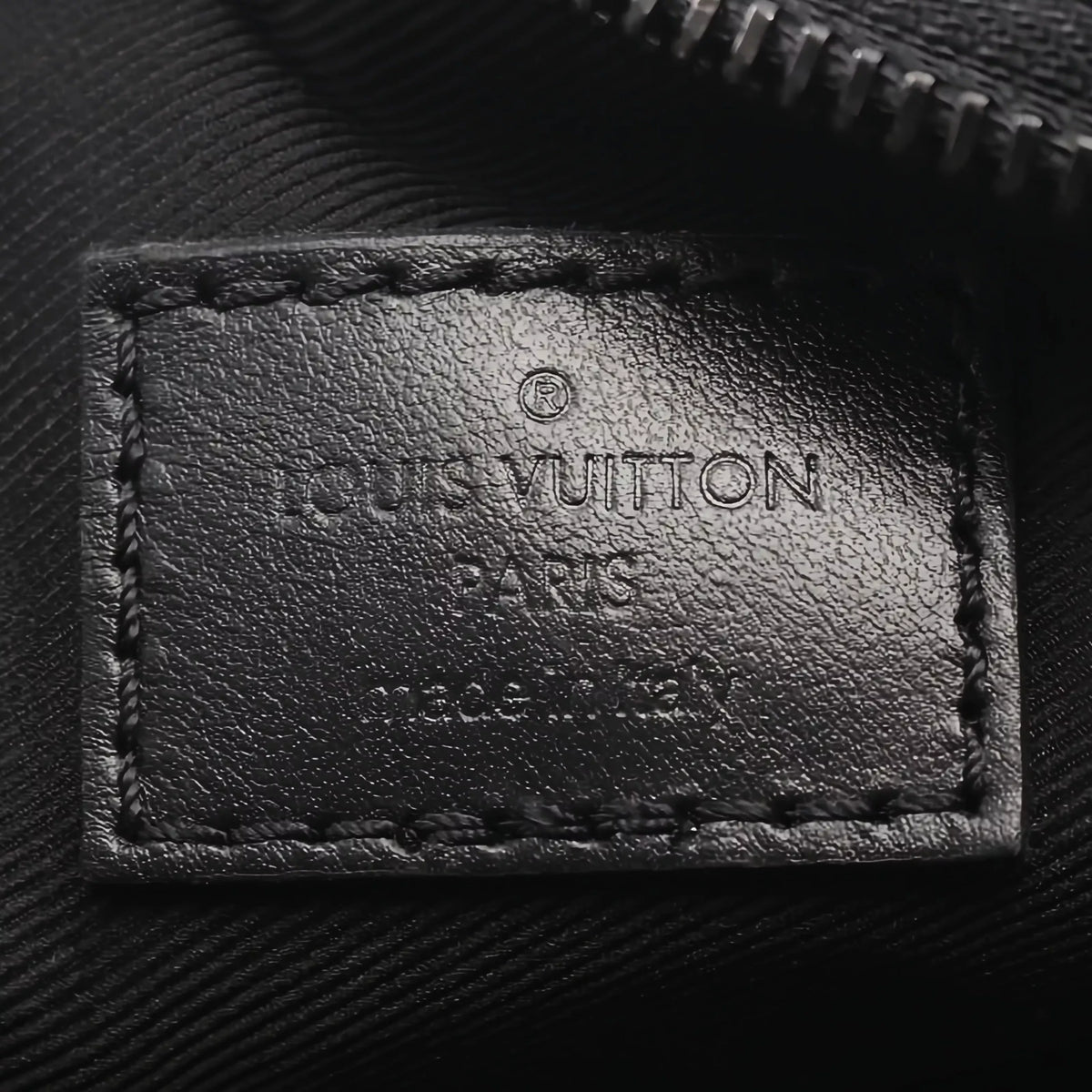 Close-up of a black leather Louis Vuitton Paris tag, made in Italy, curated Pre-loved Luxury by Myluxe in Helsinki.