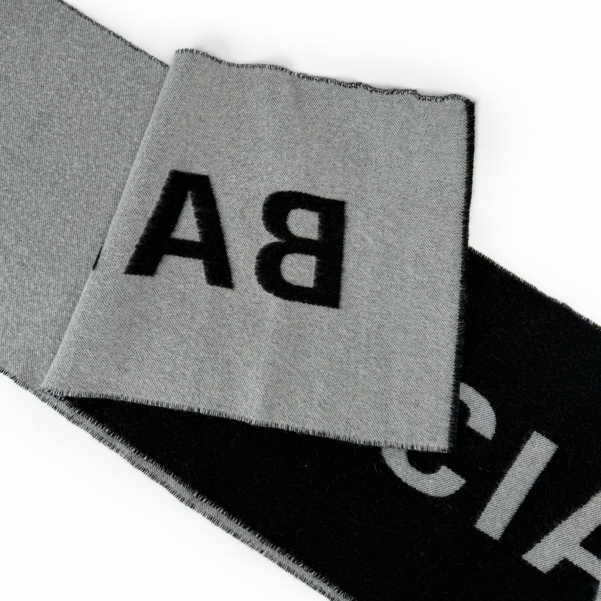 Close-up of a grey and black fabric scarf with bold black lettering, curated Pre-loved Luxury by Myluxe in Helsinki.