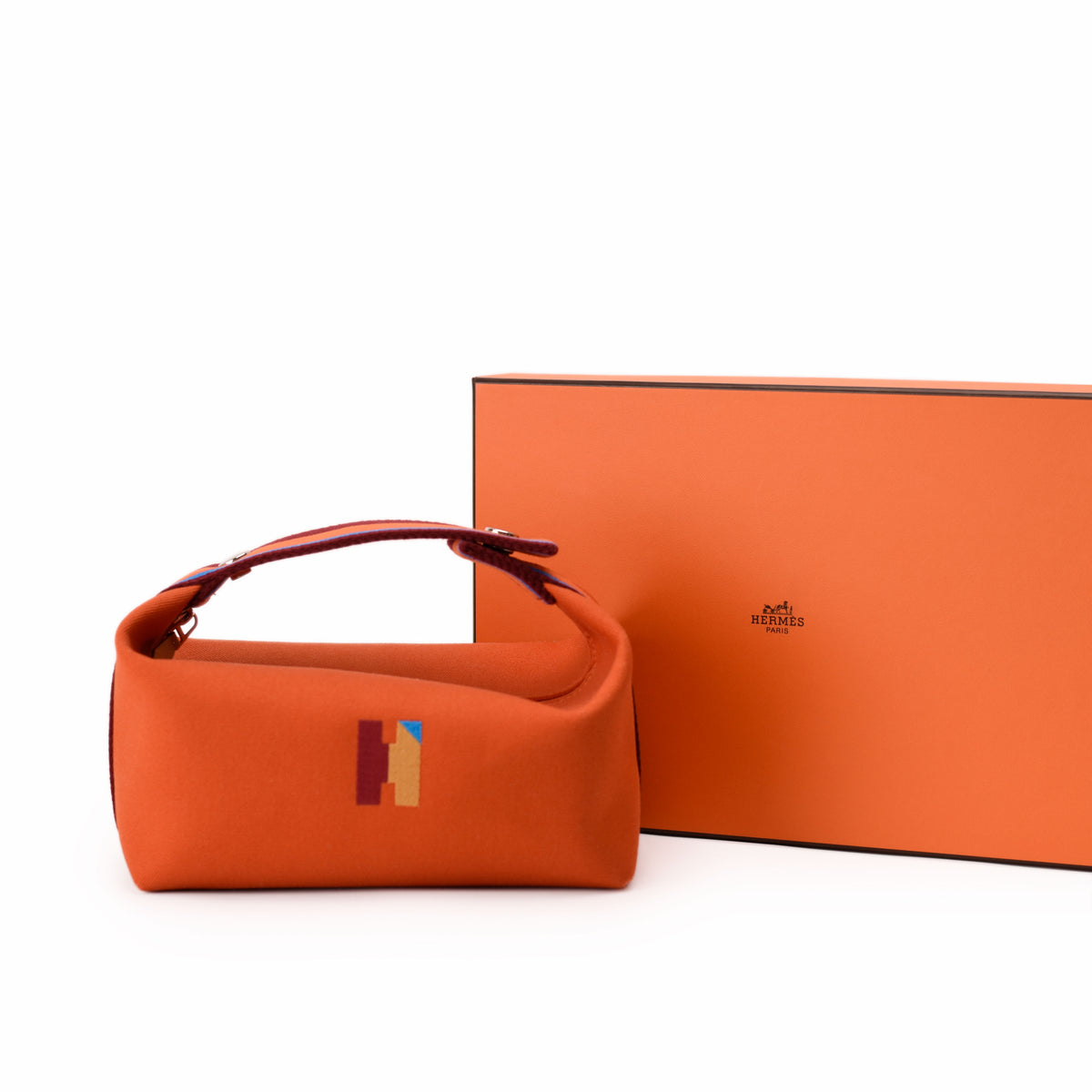 Orange Hermès leather handbag with colorful H logo. curated Pre-loved Luxury by Myluxe in Helsinki.