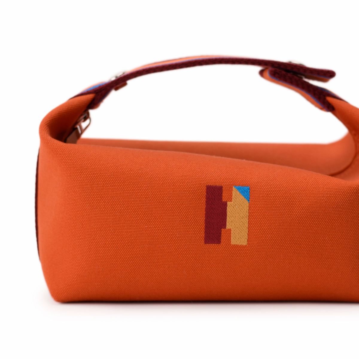 Orange canvas Hermès handbag with colorful logo detail. curated Pre-loved Luxury by Myluxe in Helsinki.