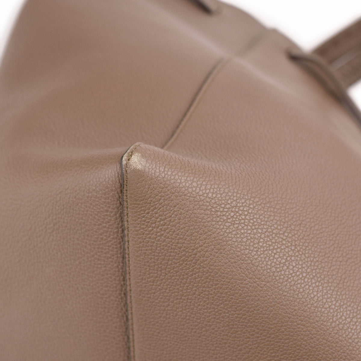 Close-up of taupe pebbled leather texture on a luxury handbag. curated Pre-loved Luxury by Myluxe in Helsinki.