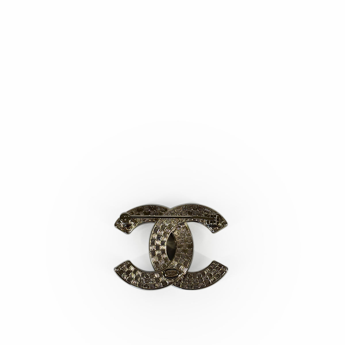 Gold-tone Chanel interlocking CC logo brooch with textured pattern, curated Pre-loved Luxury by Myluxe in Helsinki.