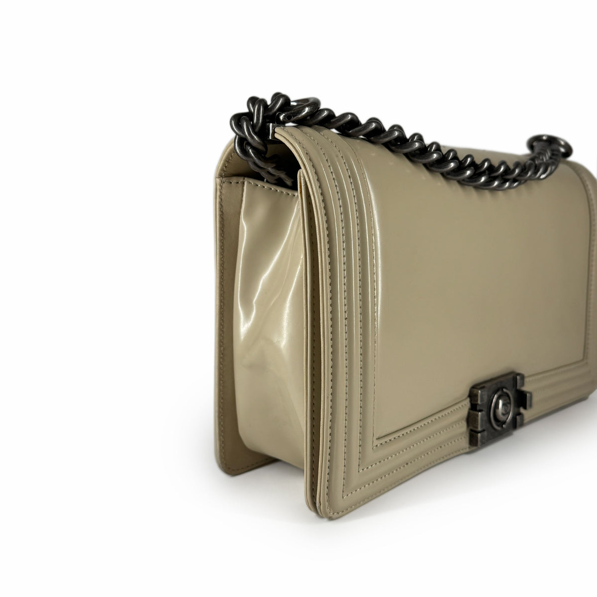 Beige patent leather flap handbag with a dark metal chain strap, curated Pre-loved Luxury by Myluxe in Helsinki.