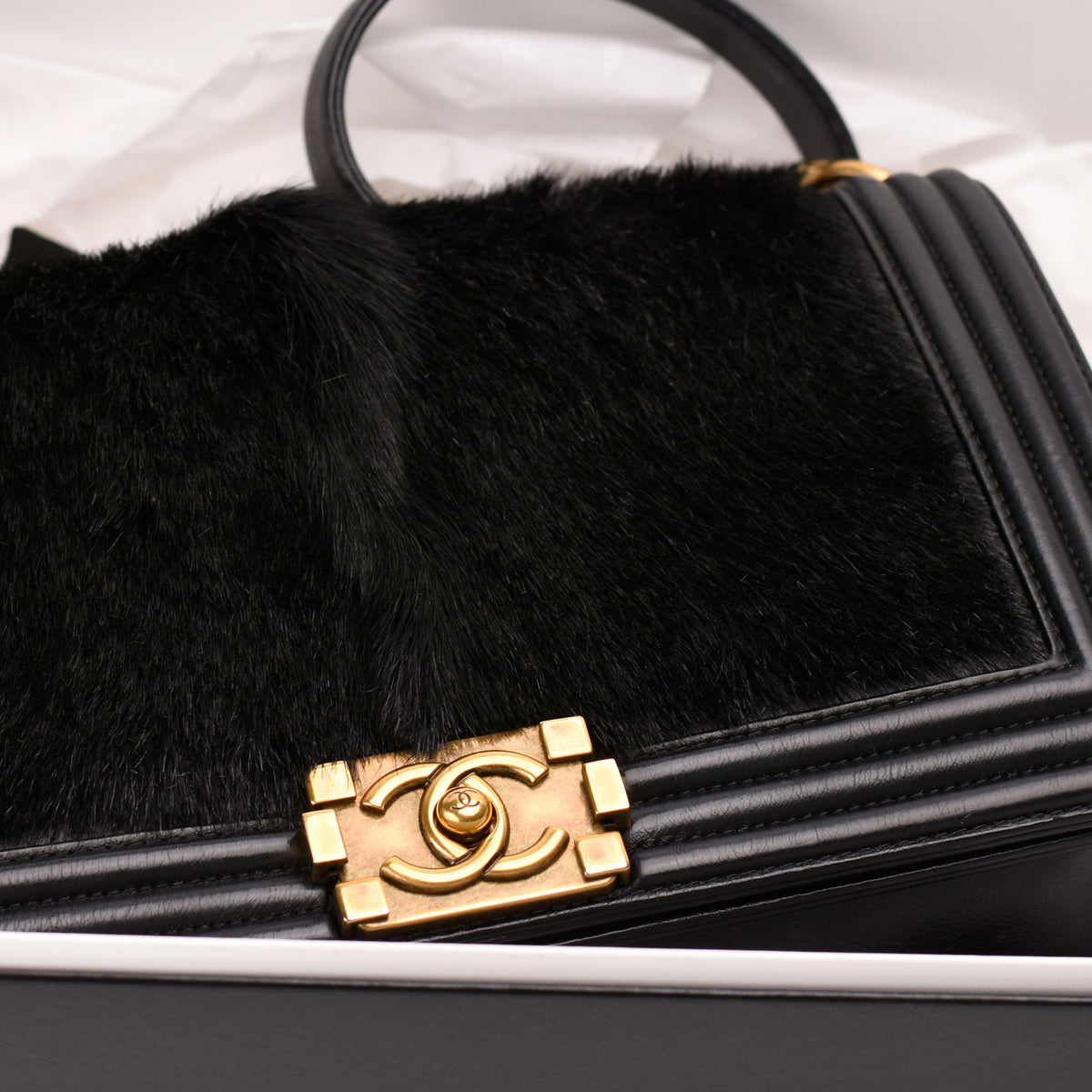 Black Chanel faux fur handbag with gold-tone interlocking CC hardware, curated Pre-loved Luxury by Myluxe in Helsinki.