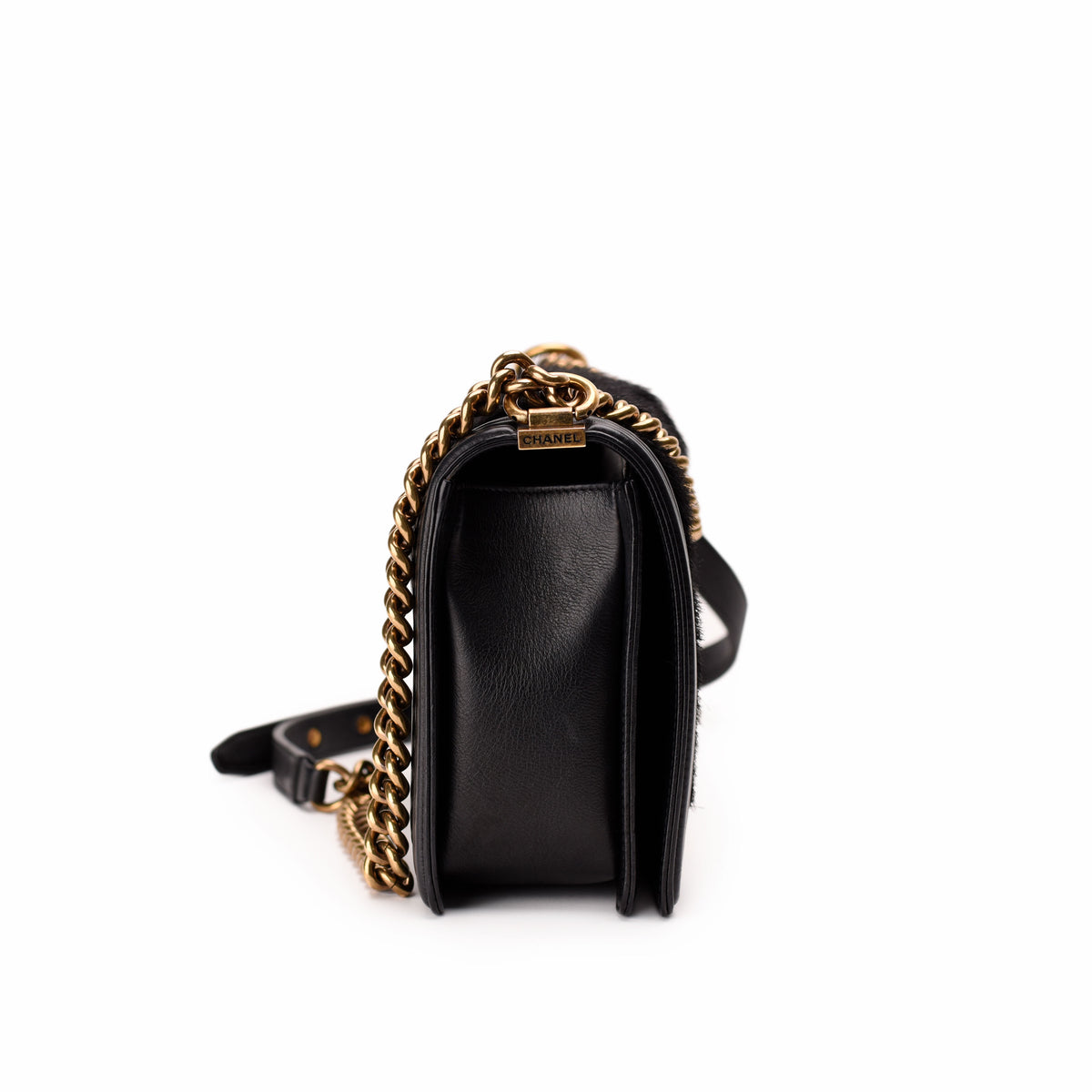 Black leather Chanel handbag with gold-tone chain strap, curated Pre-loved Luxury by Myluxe in Helsinki.