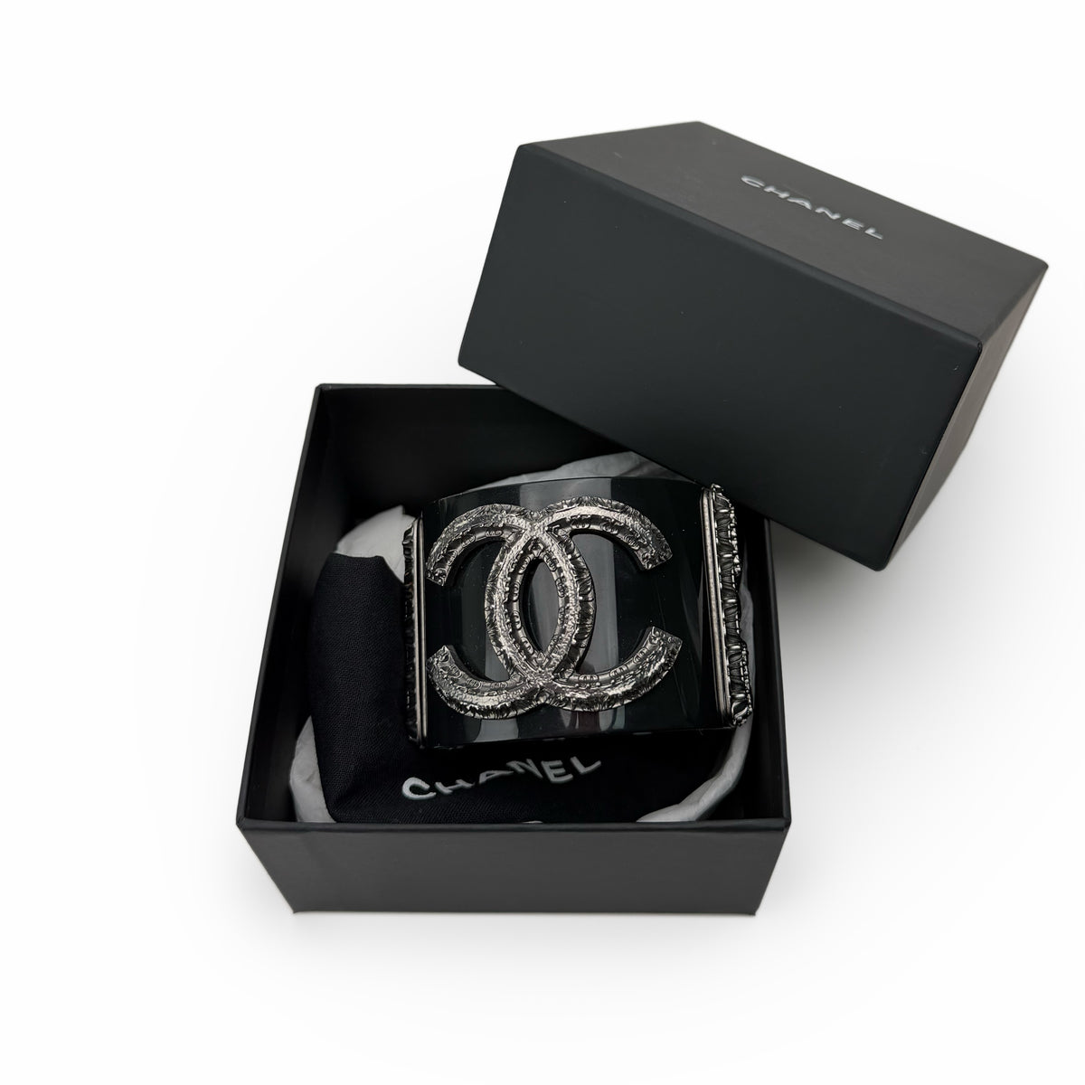 Black Chanel cuff bracelet with silver interlocking CC logo, curated Pre-loved Luxury by Myluxe in Helsinki.