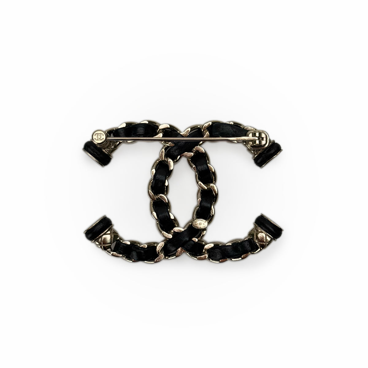 Chanel interlocking CC logo brooch in black leather and gold-tone metal, curated Pre-loved Luxury by Myluxe in Helsinki.