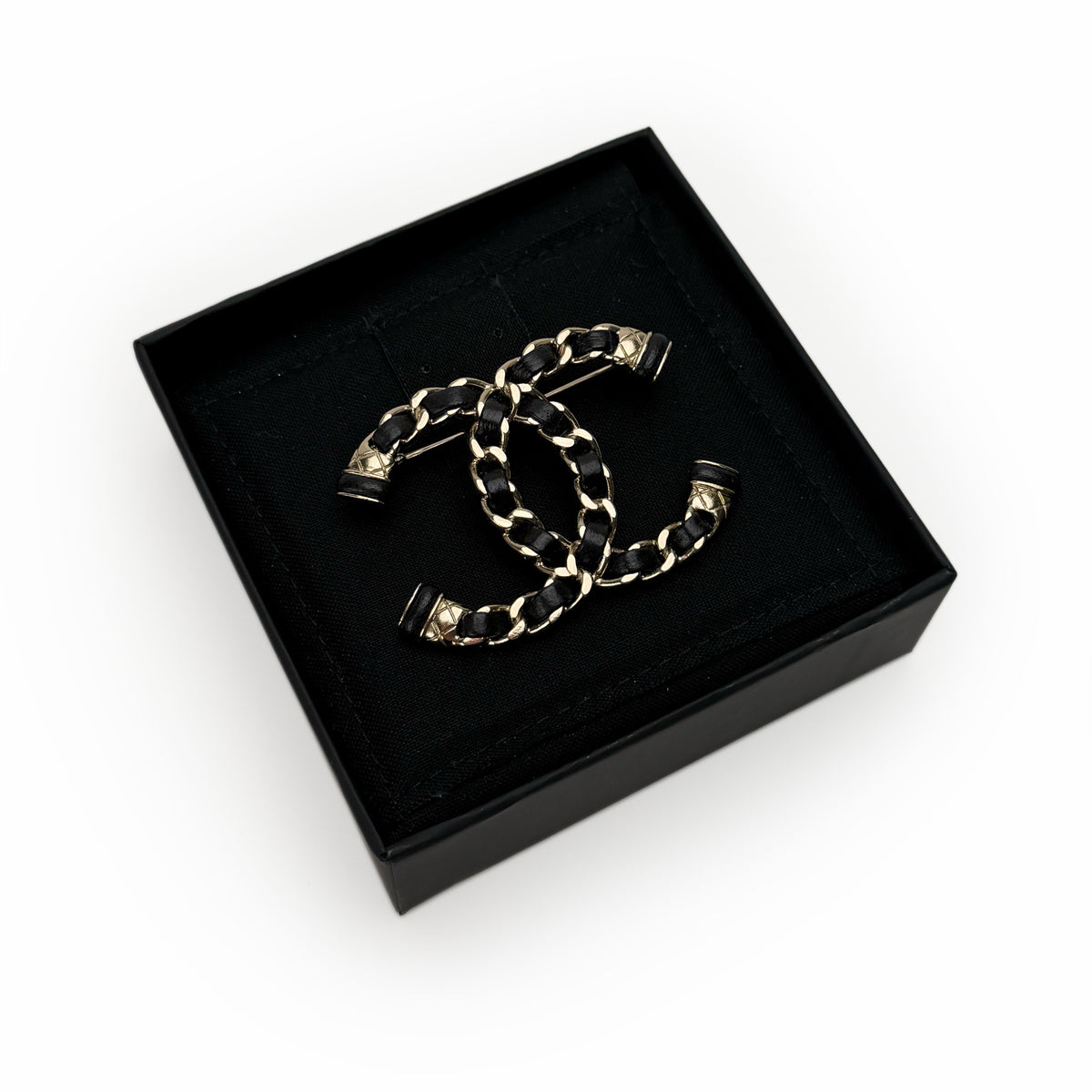 Chanel interlocking CC brooch in black leather and gold-tone metal, curated Pre-loved Luxury by Myluxe in Helsinki.