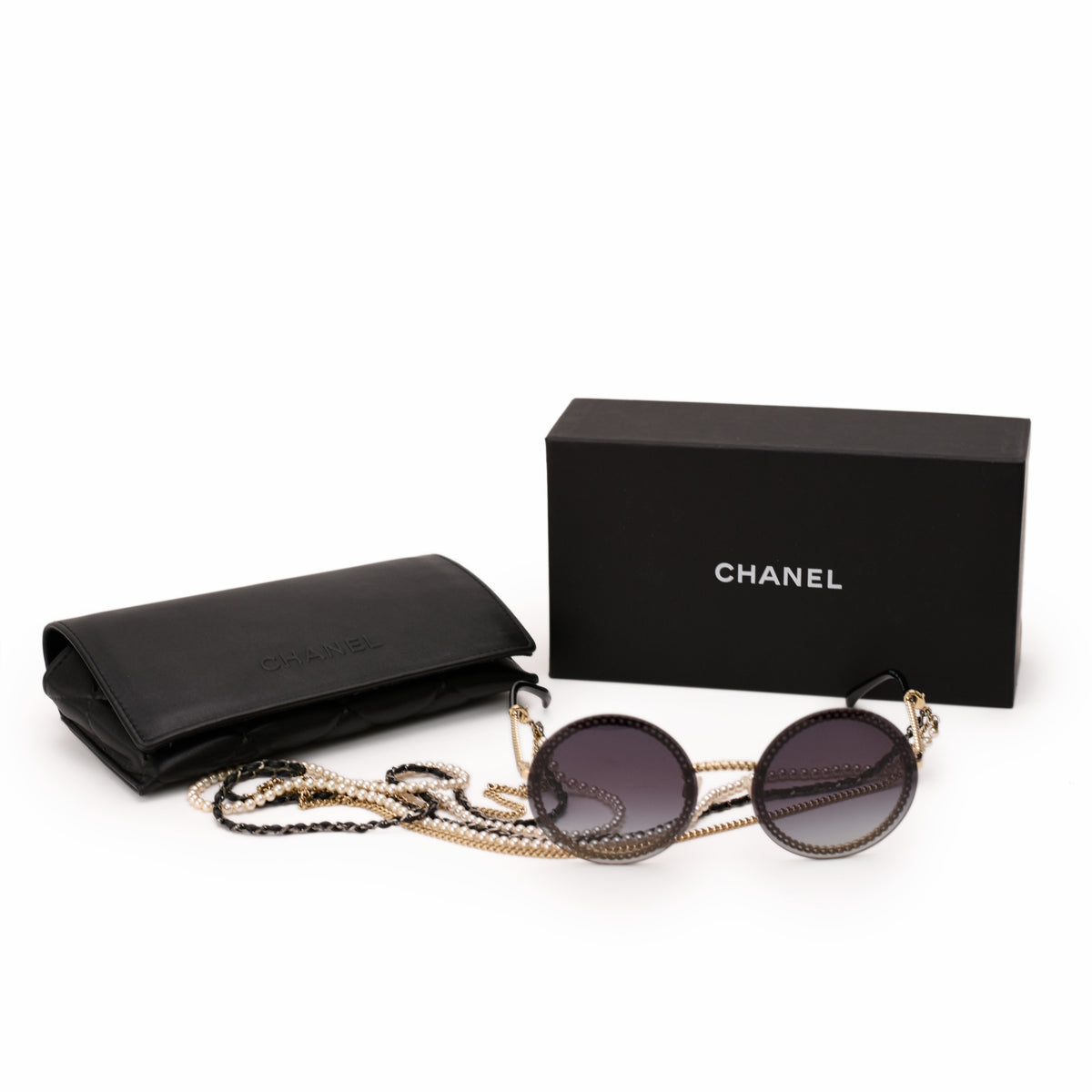 Black Chanel sunglasses with gold chain detail and matching leather case, curated Pre-loved Luxury by Myluxe in Helsinki.