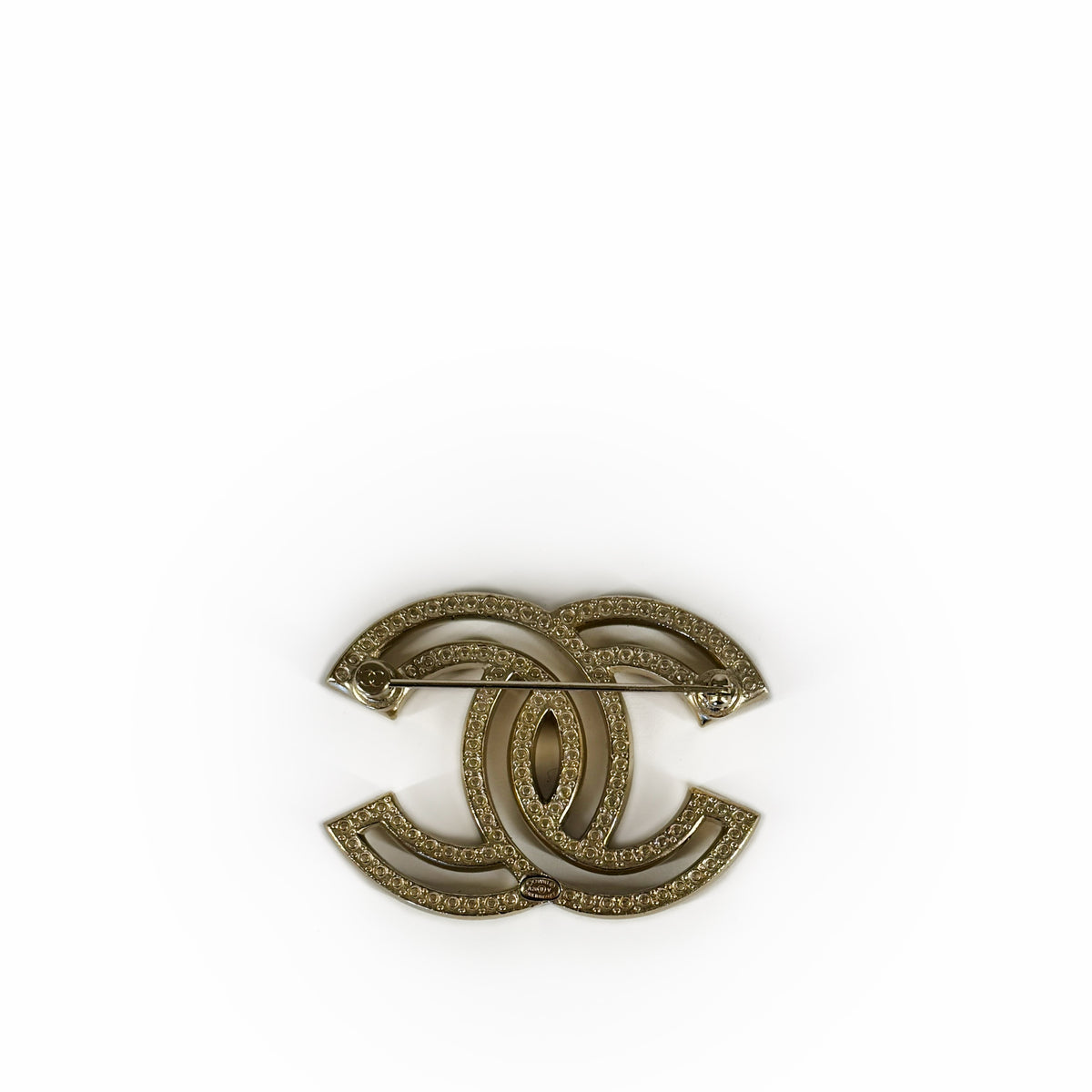 Gold-tone interlocking CC logo brooch with textured finish, curated Pre-loved Luxury by Myluxe in Helsinki.