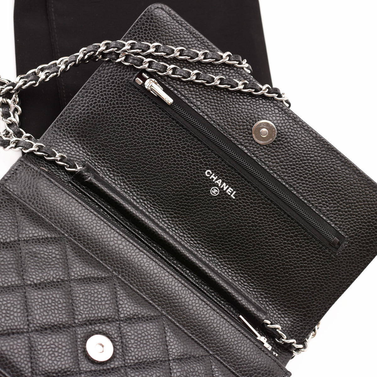 Interior of a black pebbled leather Chanel shoulder bag with silver-tone chain. curated Pre-loved Luxury by Myluxe in Helsinki.