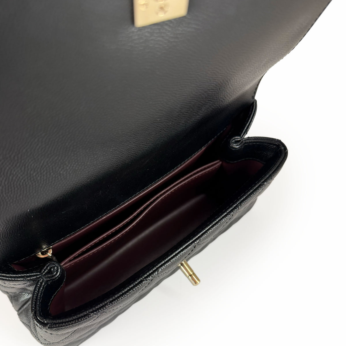Interior view of a black grained leather luxury handbag with gold hardware, curated Pre-loved Luxury by Myluxe in Helsinki.