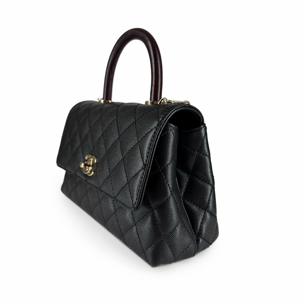 Black quilted leather handbag with gold hardware and top handle, curated Pre-loved Luxury by Myluxe in Helsinki.