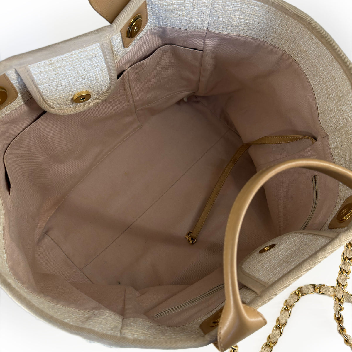 Interior view of a beige woven tote bag with tan leather handles and gold hardware, curated Pre-loved Luxury by Myluxe in Helsinki.