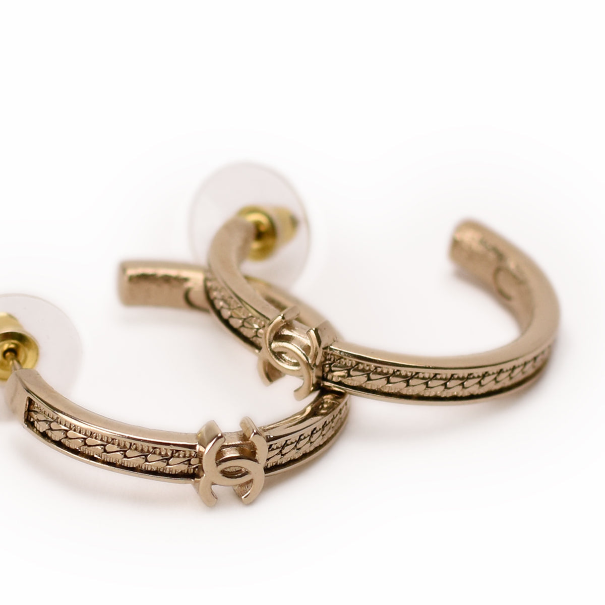 Chanel gold-tone hoop earrings with interlocking CC logo detail. Curated Pre-loved Luxury by Myluxe in Helsinki.