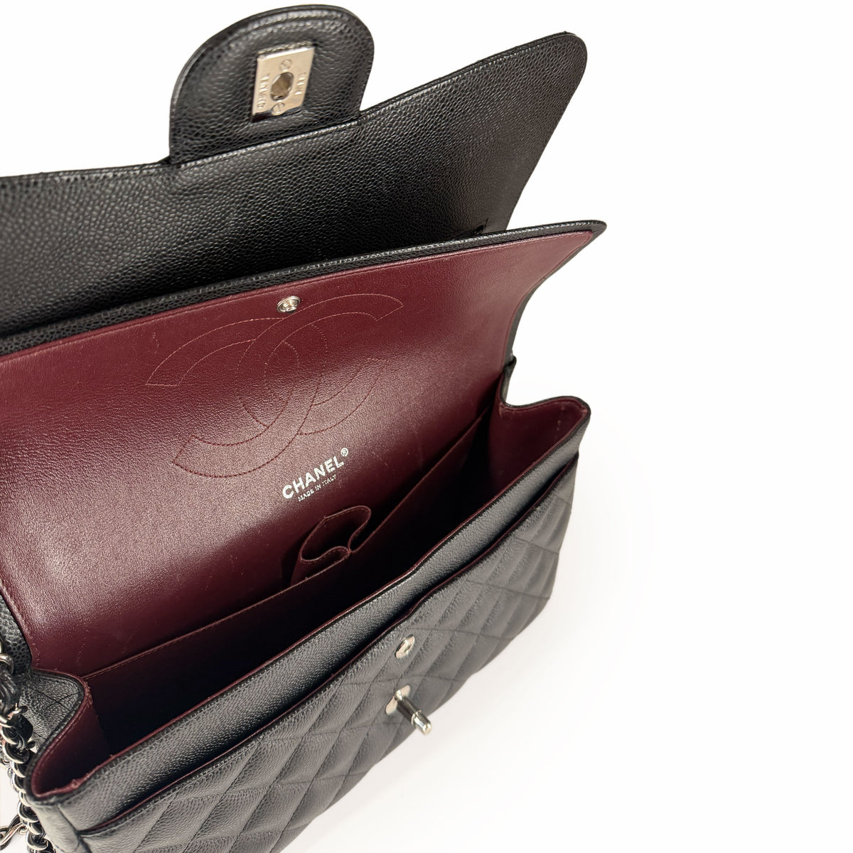 Interior view of a black quilted Chanel handbag with burgundy leather lining, curated Pre-loved Luxury by Myluxe in Helsinki.