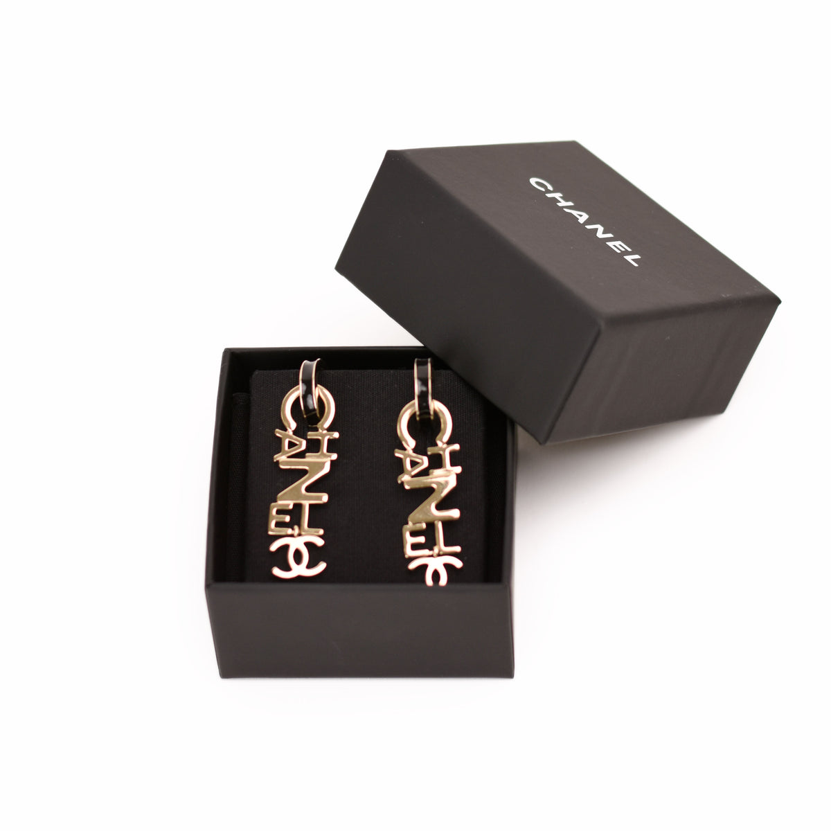 Chanel gold-tone logo drop earrings in a black box. curated Pre-loved Luxury by Myluxe in Helsinki.