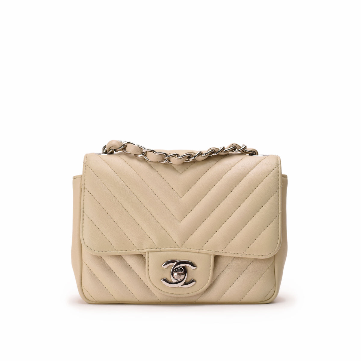 Beige chevron quilted leather Chanel flap bag with silver chain strap, curated Pre-loved Luxury by Myluxe in Helsinki.