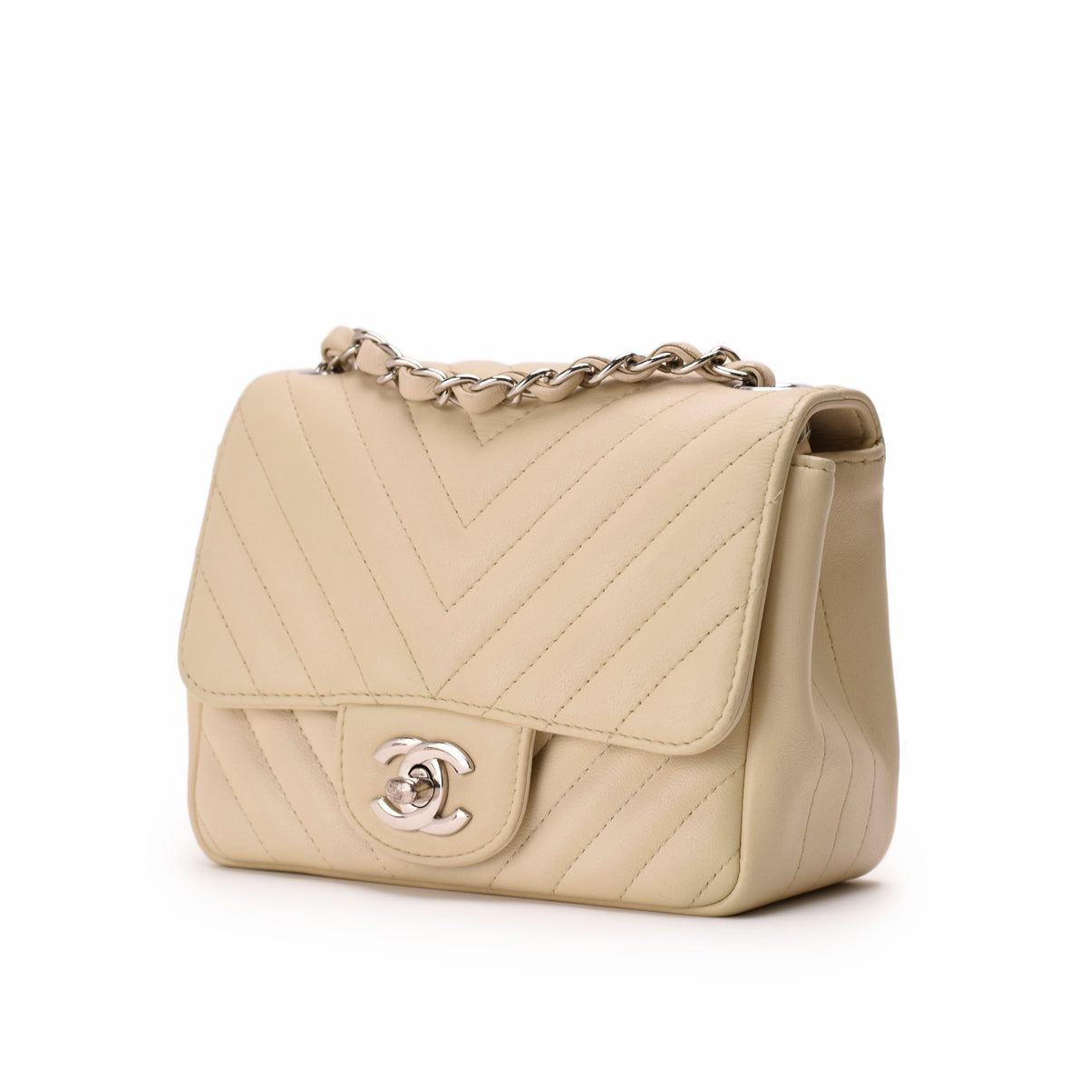 Beige quilted leather Chanel flap bag with silver chain strap, curated Pre-loved Luxury by Myluxe in Helsinki.