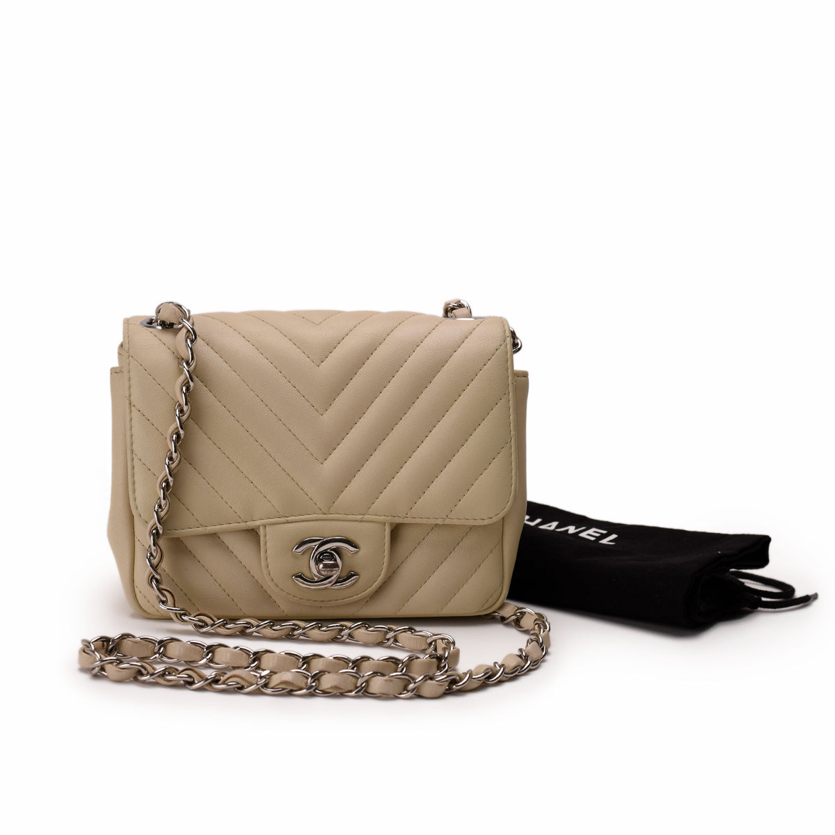 Beige quilted leather Chanel flap bag with silver chain strap, curated Pre-loved Luxury by Myluxe in Helsinki.