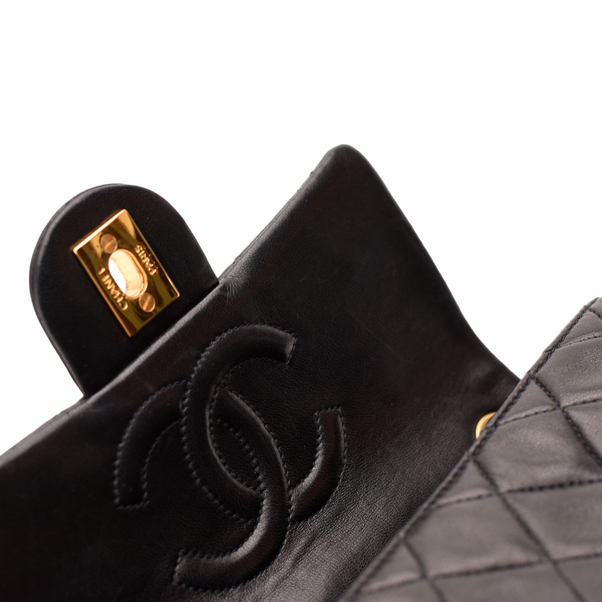 Black quilted leather Chanel flap bag with gold-tone hardware, curated Pre-loved Luxury by Myluxe in Helsinki.