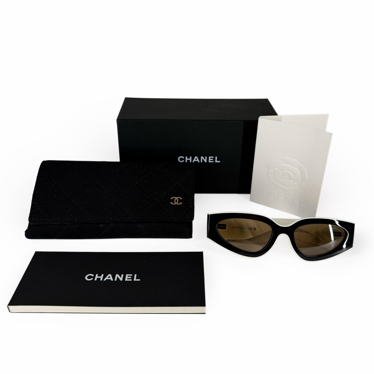 Black Chanel quilted leather wallet, sunglasses, and brand accessories, curated Pre-loved Luxury by Myluxe in Helsinki.