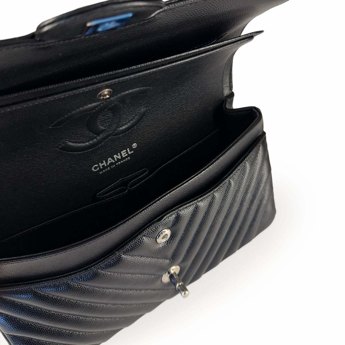 Interior view of a black quilted Chanel handbag with silver hardware, curated Pre-loved Luxury by Myluxe in Helsinki.