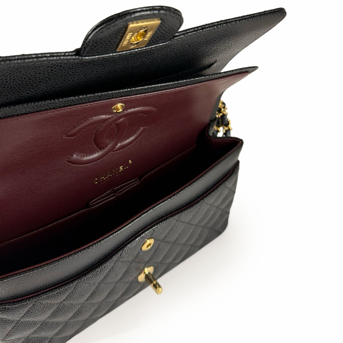 Interior view of a black quilted leather Chanel handbag with burgundy lining, curated Pre-loved Luxury by Myluxe in Helsinki.