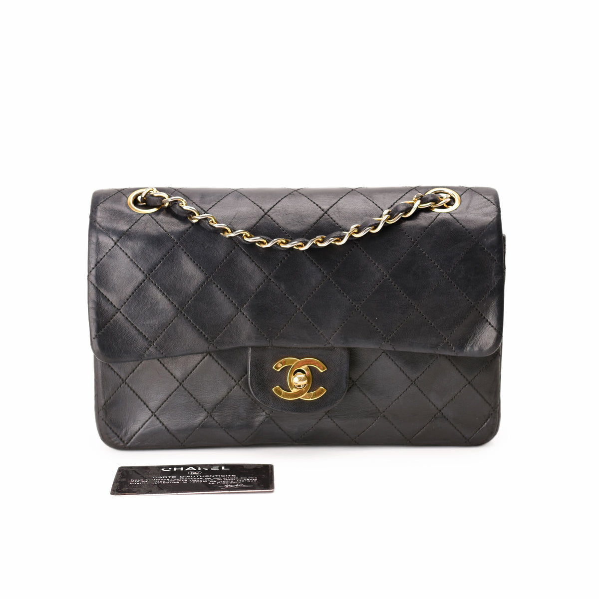 Black quilted leather Chanel handbag with gold chain and CC logo, curated Pre-loved Luxury by Myluxe in Helsinki.
