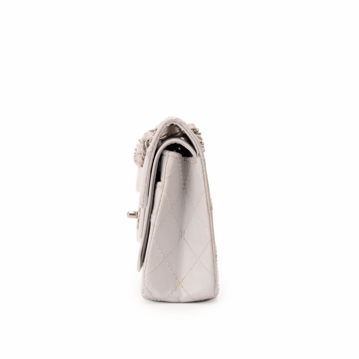 Side view of a white quilted leather designer handbag, curated Pre-loved Luxury by Myluxe in Helsinki.