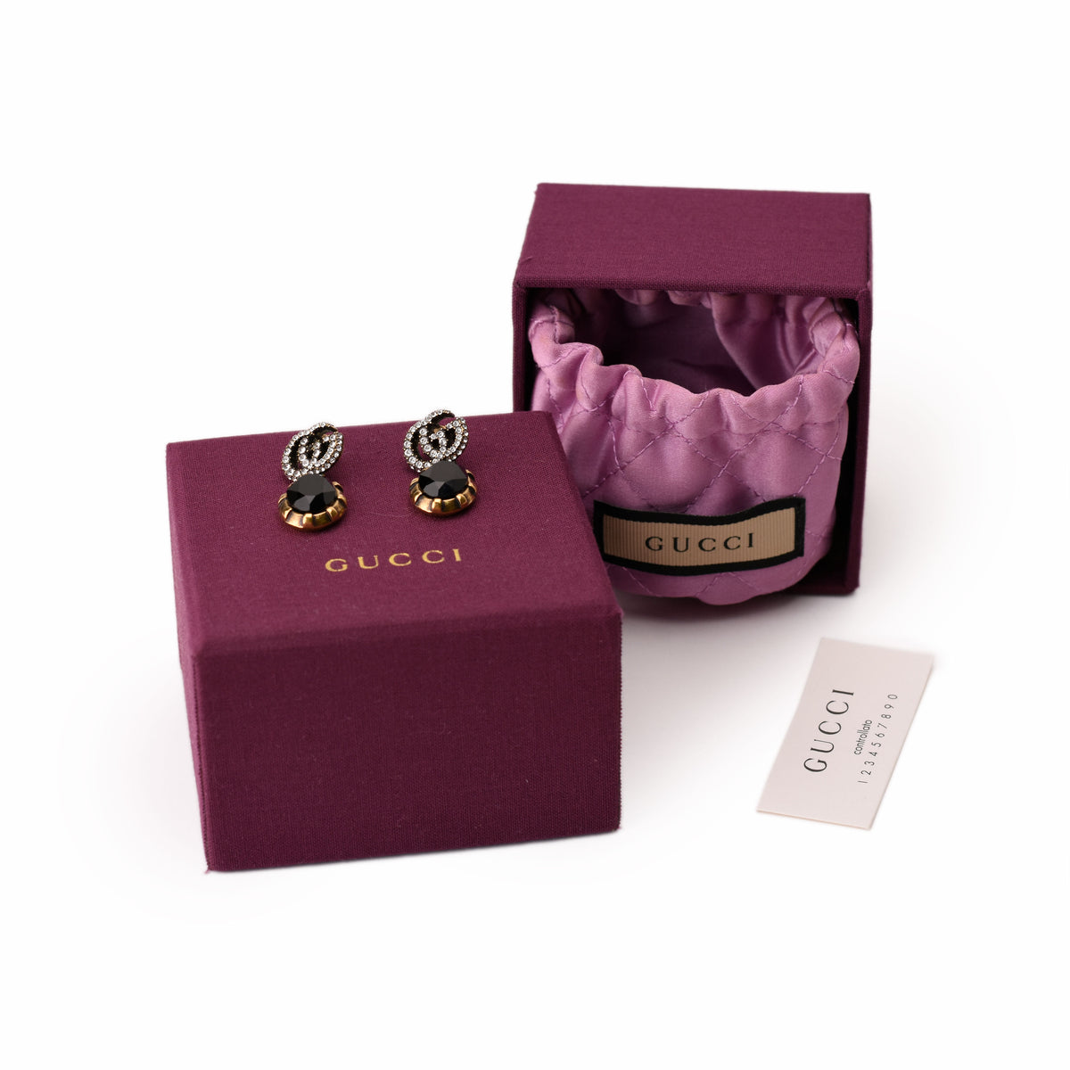 Gucci gold earrings with black gemstones and diamonds in a purple box, curated Pre-loved Luxury by Myluxe in Helsinki.