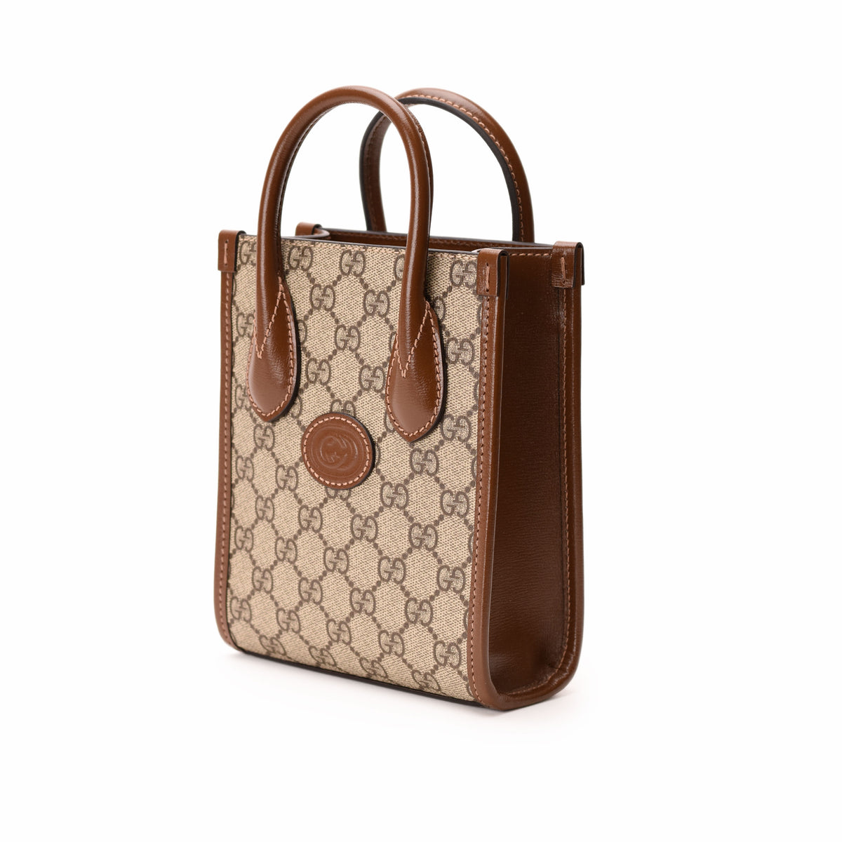 Gucci Interlocking G mini tote bag in GG Supreme canvas with leather handles and gold-tone hardware.