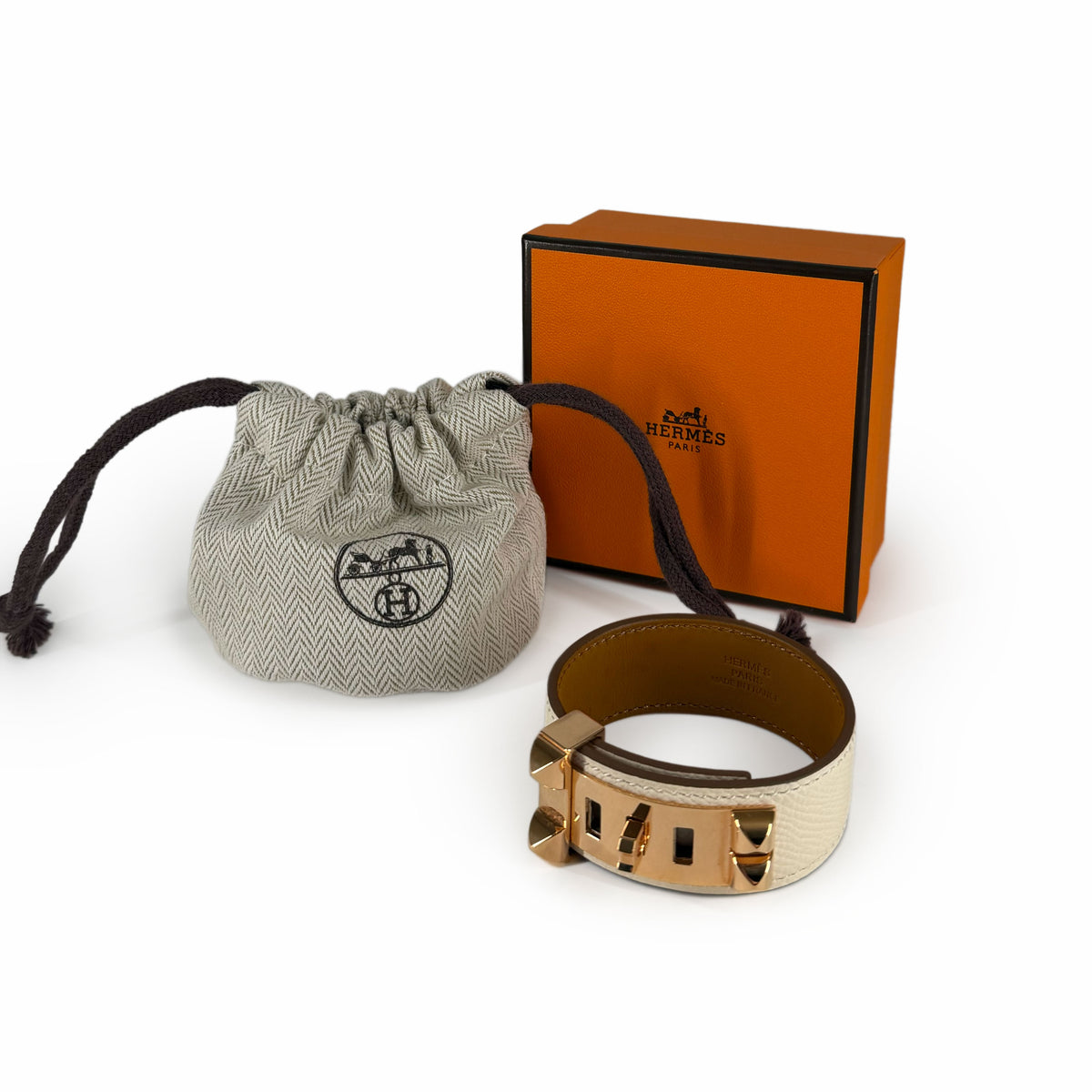 Hermès gold-tone hardware leather cuff bracelet with grey fabric dust bag, curated Pre-loved Luxury by Myluxe in Helsinki.