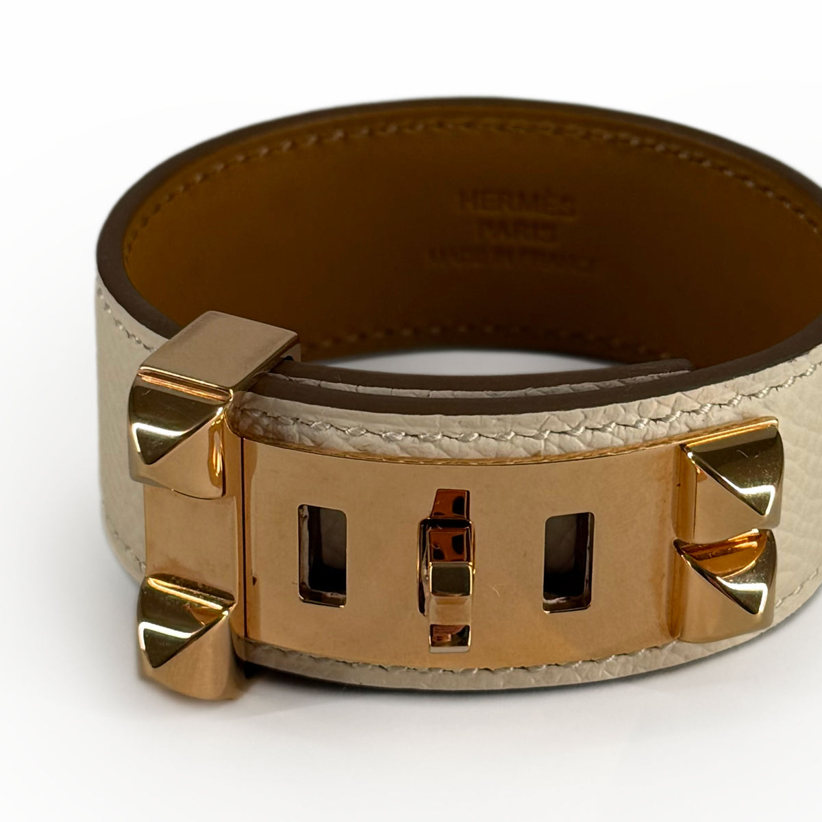 Hermès gold-tone metal and white leather bracelet, curated Pre-loved Luxury by Myluxe in Helsinki.