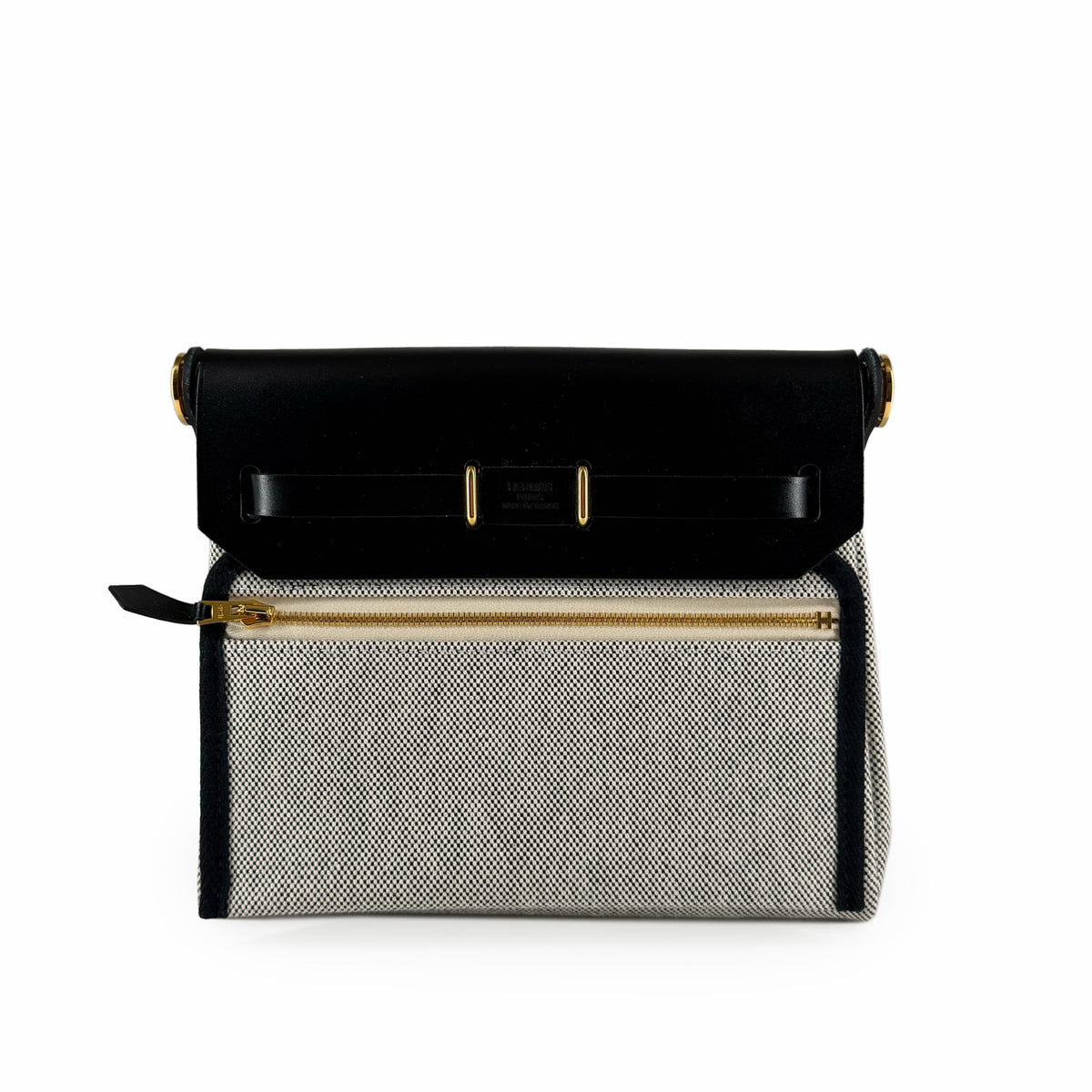 Hermès black leather and cream canvas flap bag with gold hardware, curated Pre-loved Luxury by Myluxe in Helsinki.