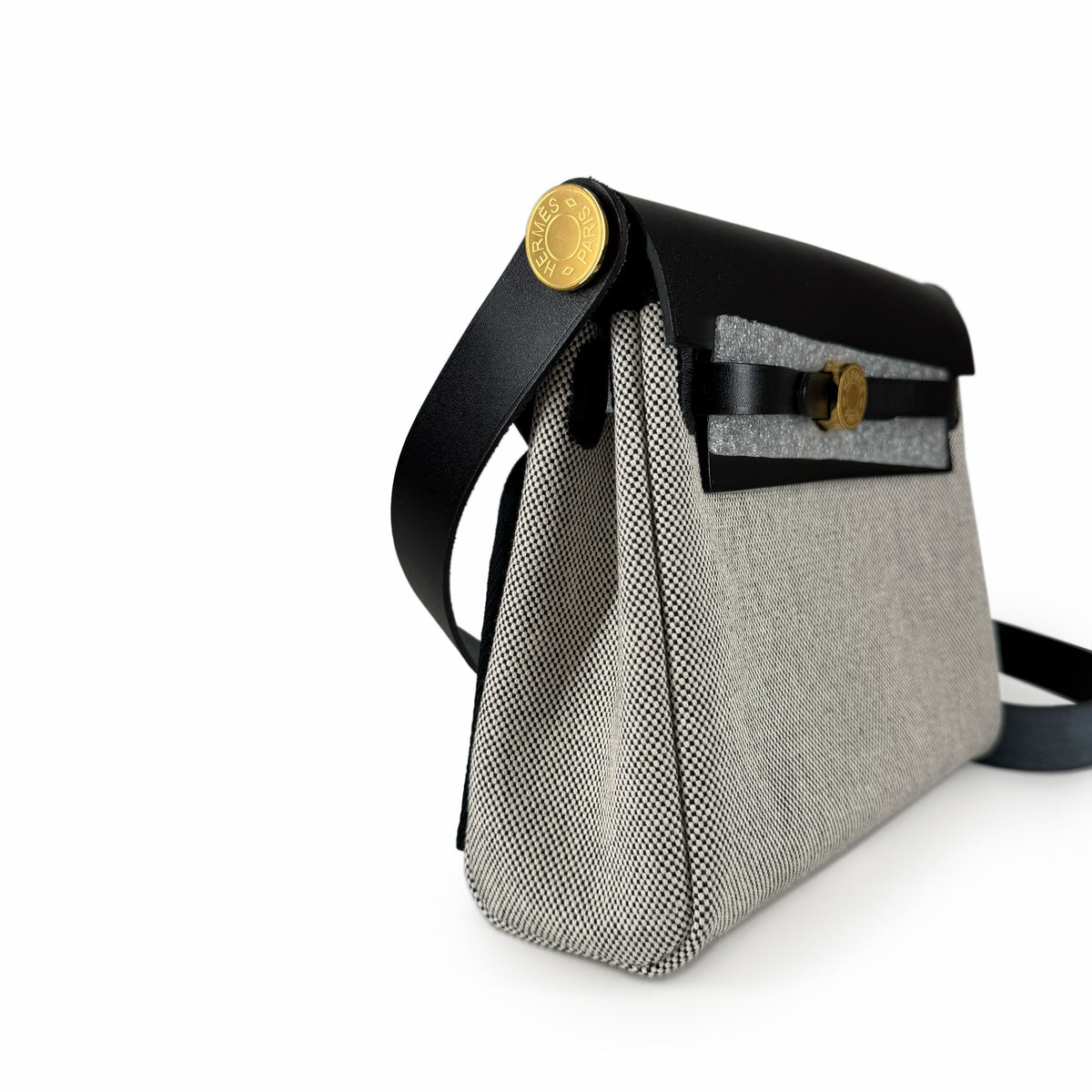 Hermès crossbody bag in grey canvas and black leather with gold hardware, curated Pre-loved Luxury by Myluxe in Helsinki.
