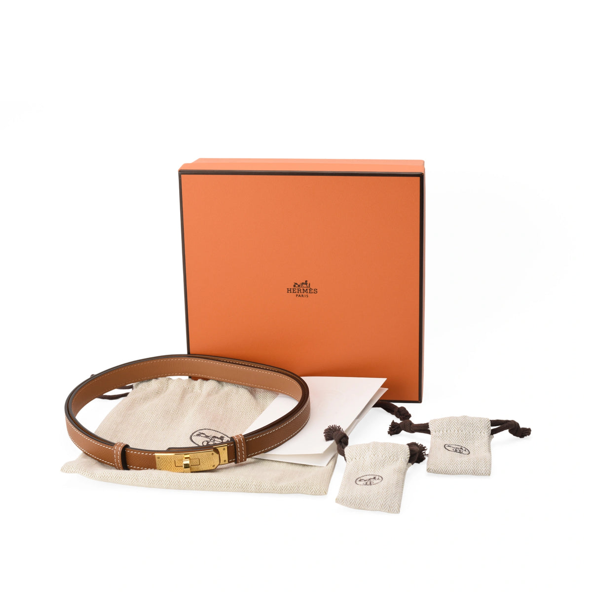Brown leather Hermès belt with gold buckle and orange gift box, curated Pre-loved Luxury by Myluxe in Helsinki.