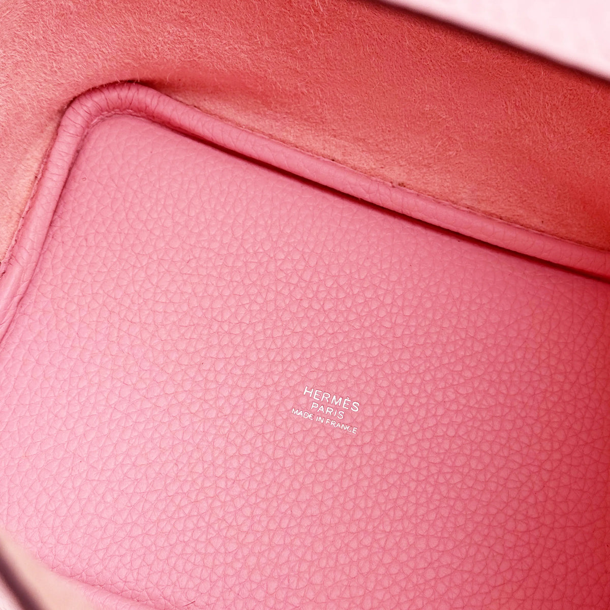 Interior of a pink leather Hermès handbag with embossed logo, curated Pre-loved Luxury by Myluxe in Helsinki.