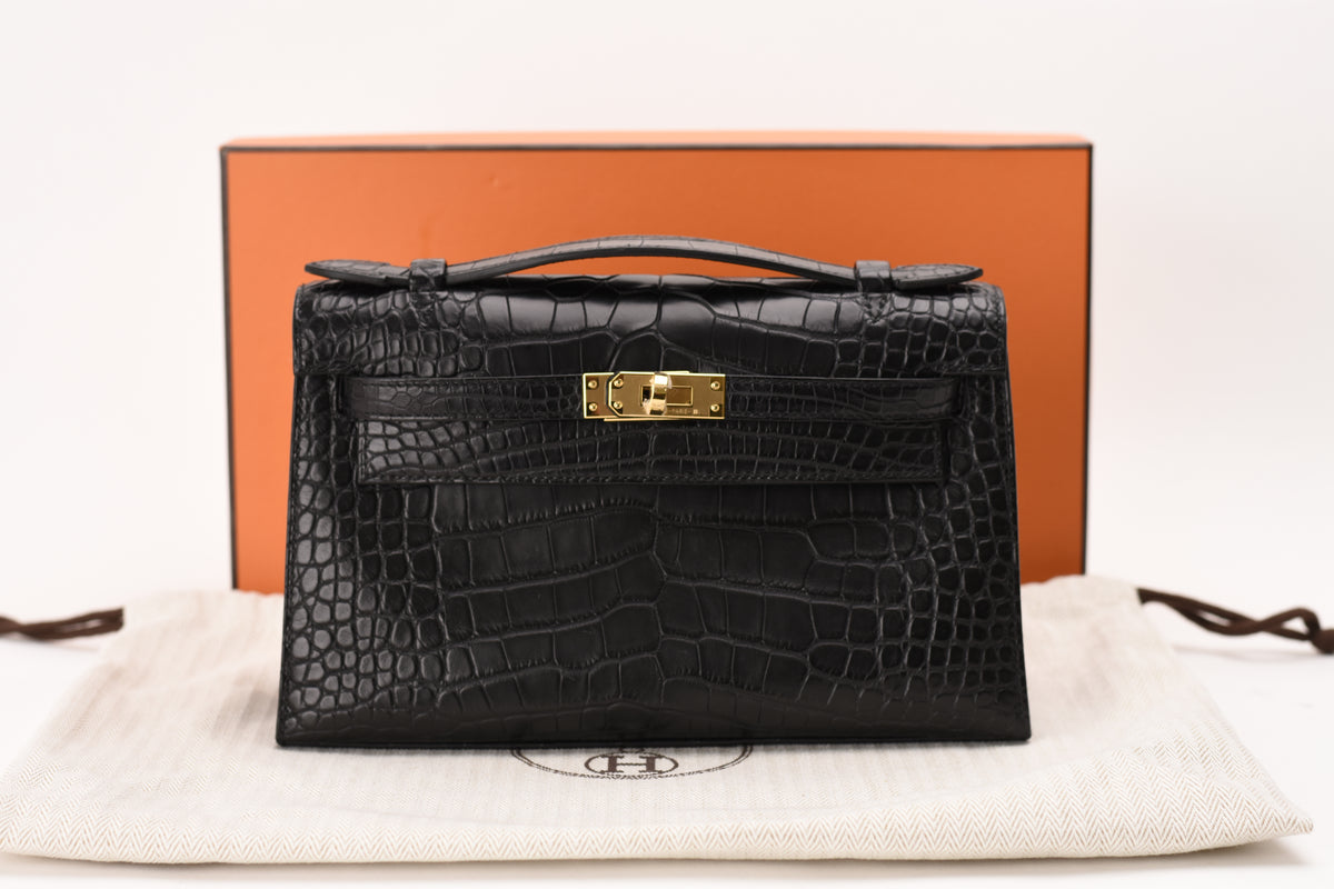 Hermès Kelly Pochette in black matte alligator with gold hardware. curated Pre-loved Luxury by Myluxe in Helsinki.