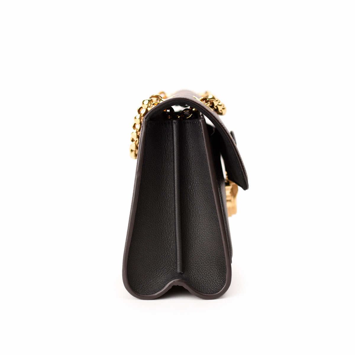 Side view of a black leather Chanel handbag with gold chain strap, curated Pre-loved Luxury by Myluxe in Helsinki.