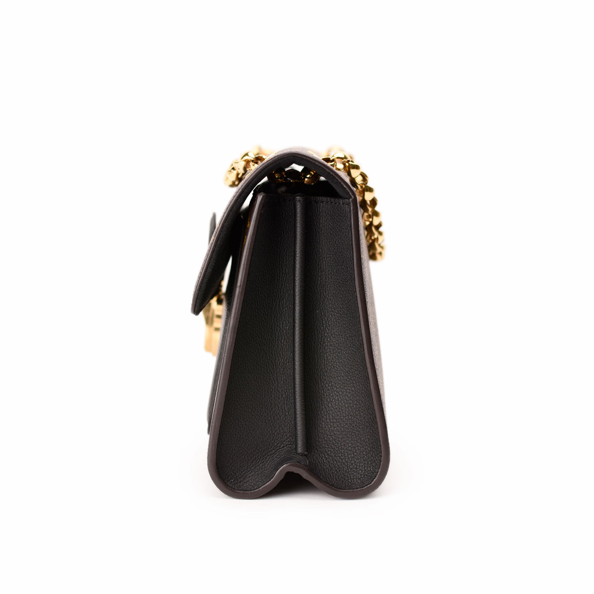 Side view of a black grained leather Chanel handbag with gold-tone chain strap, curated Pre-loved Luxury by Myluxe in Helsinki.
