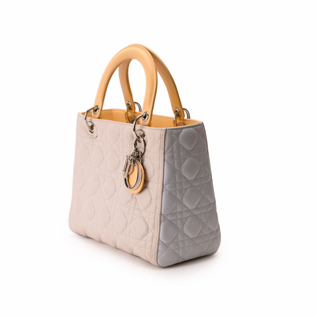Light beige quilted Dior handbag with tan leather handles and CD charm, curated Pre-loved Luxury by Myluxe in Helsinki.