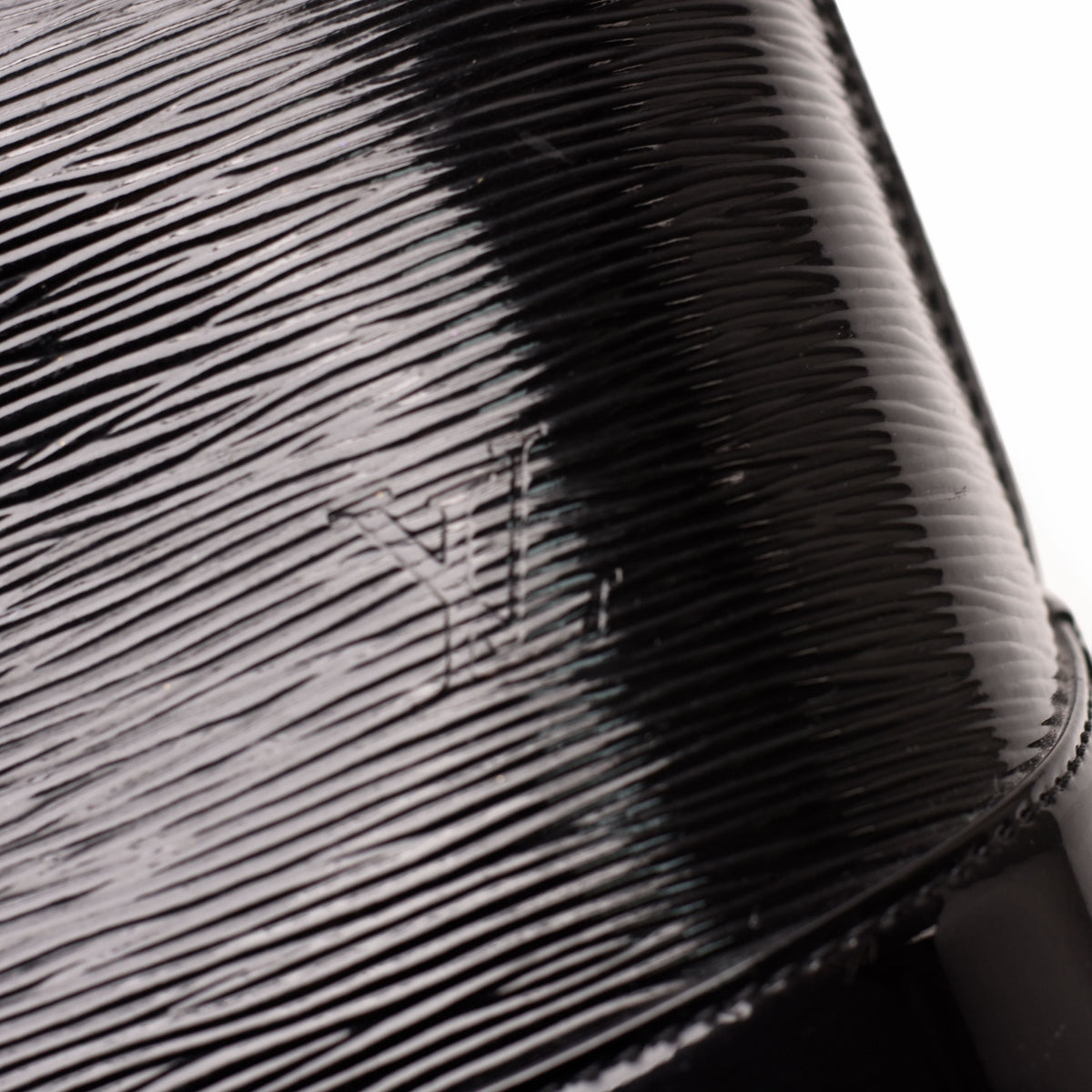 Close-up of black textured patent leather material with subtle grain, curated Pre-loved Luxury by Myluxe in Helsinki.