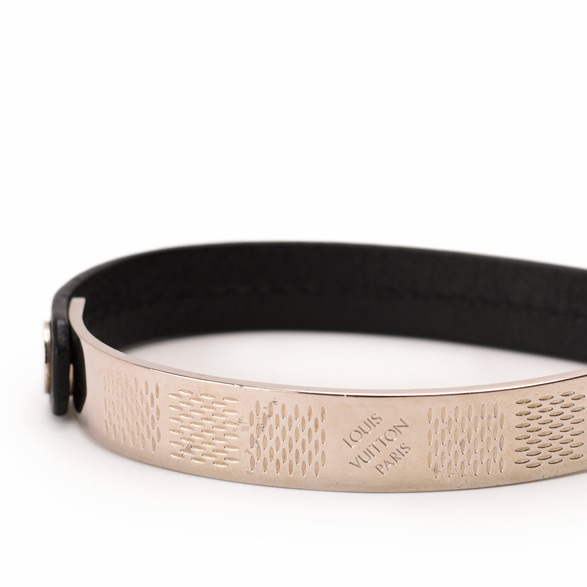Louis Vuitton gold-tone engraved metal bangle with black leather band, curated Pre-loved Luxury by Myluxe in Helsinki.