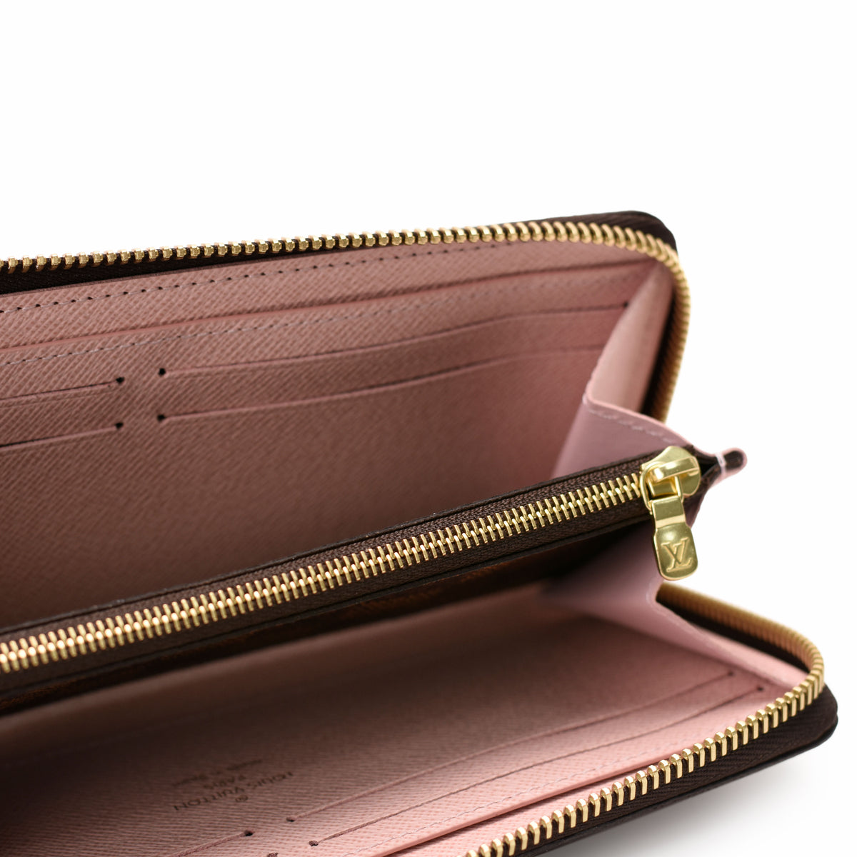 Interior of a brown monogram leather wallet with pink lining and gold-tone hardware, curated Pre-loved Luxury by Myluxe in Helsinki.