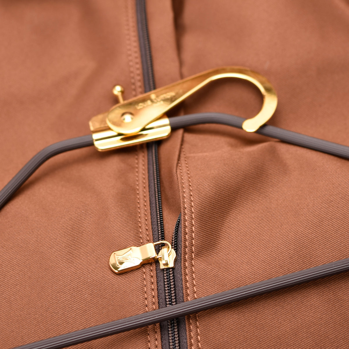 Close-up of a brown fabric bag with gold-toned hardware and zippers, curated Pre-loved Luxury by Myluxe in Helsinki.