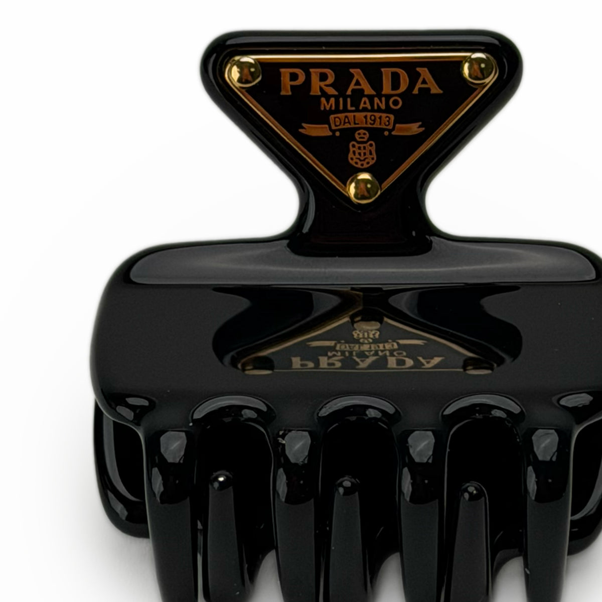 Black Prada Milano hair claw clip with gold logo detail, curated Pre-loved Luxury by Myluxe in Helsinki.