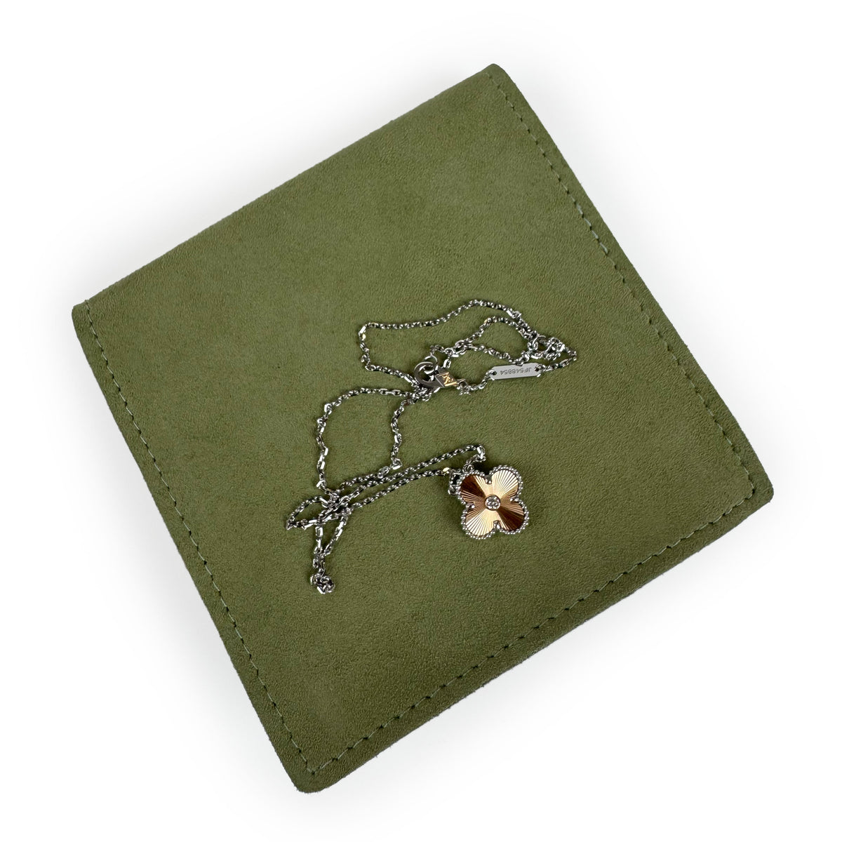 Gold flower pendant necklace on an olive green suede wallet, curated Pre-loved Luxury by Myluxe in Helsinki.