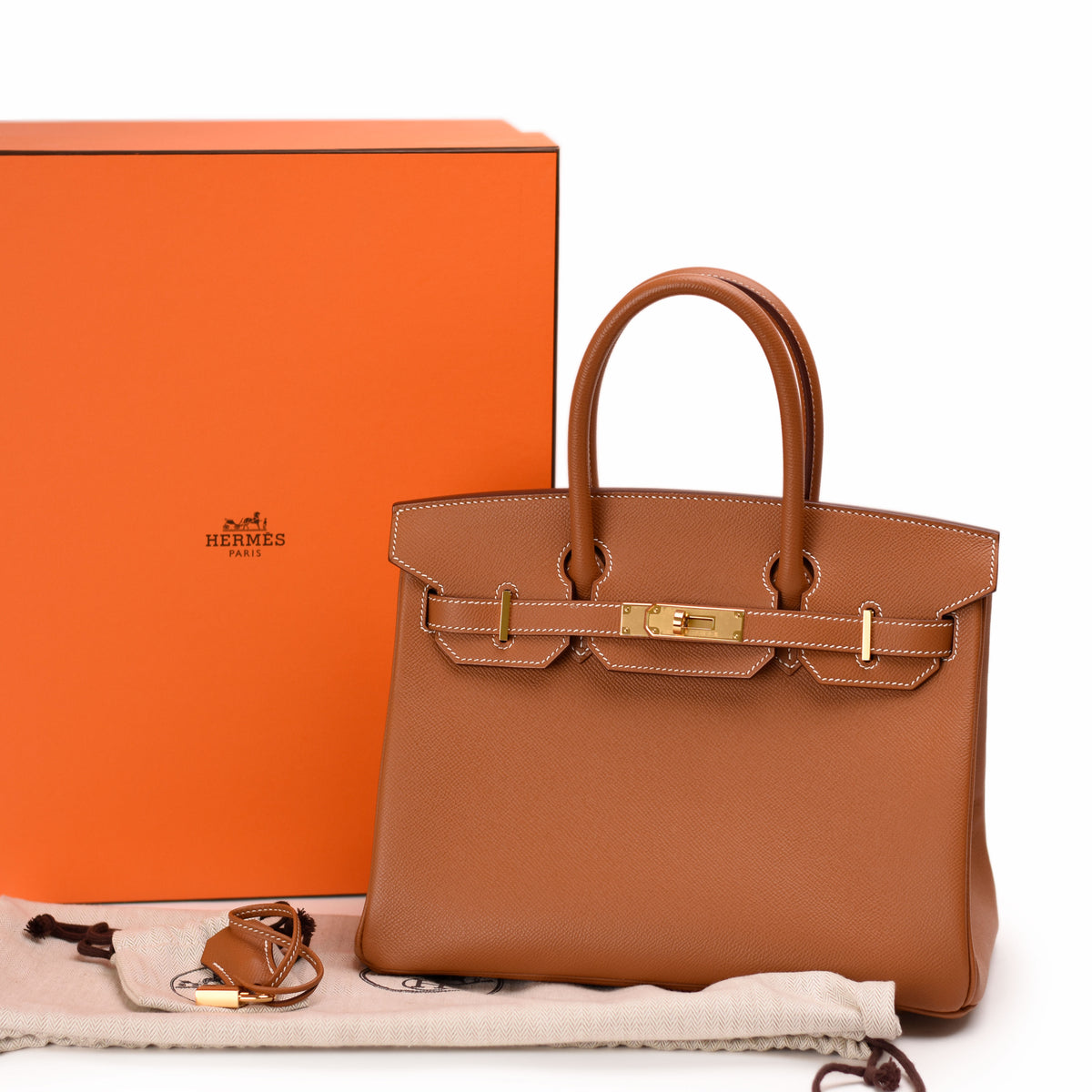 Hermès brown leather handbag with gold hardware and orange box. curated Pre-loved Luxury by Myluxe in Helsinki.