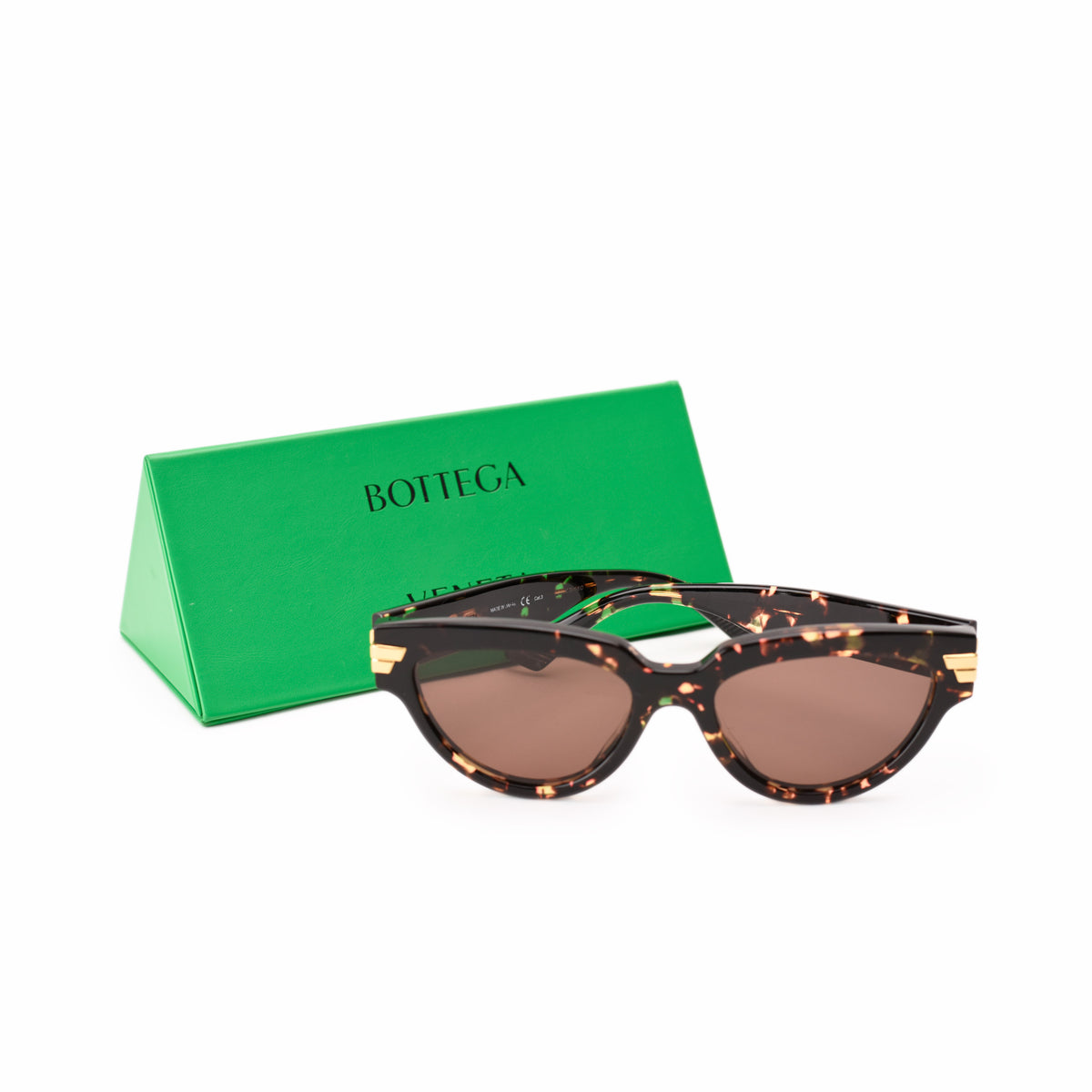 Bottega Veneta tortoise shell sunglasses with gold accents and green box, curated Pre-loved Luxury by Myluxe in Helsinki.